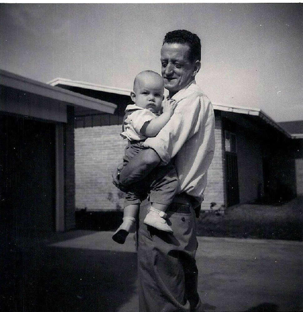Baby Terry L. Fossum in his father's arms outside their home