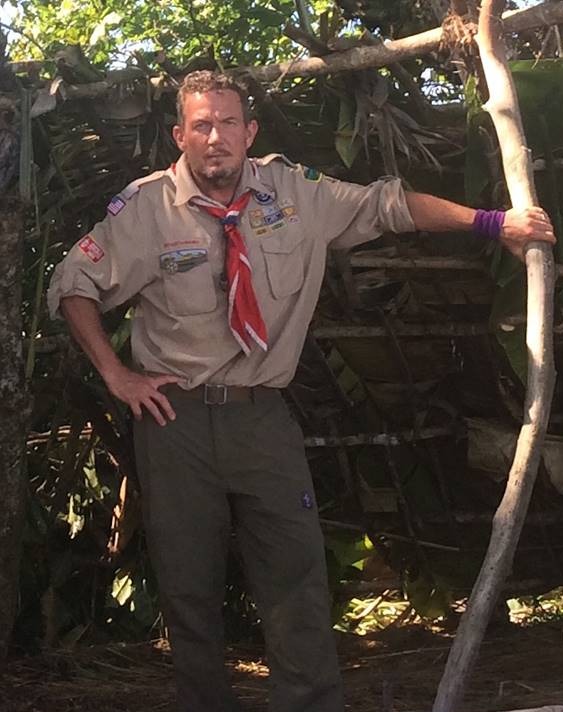 Terry L. Fossum in his Scoutmaster uniform beside a jungle survival shelter on Fox’s Kicking & Screaming