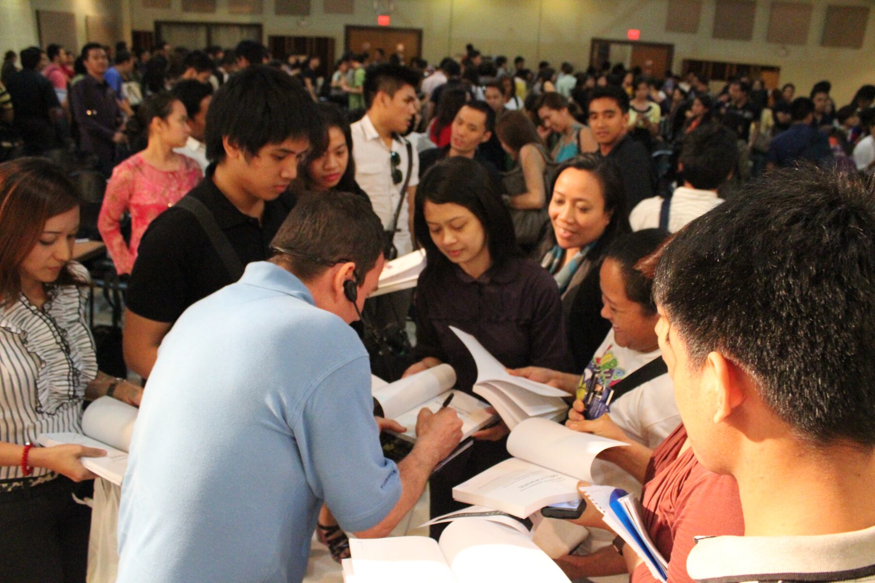 Terry L. Fossum signing books, surrounded by a large crowd of readers